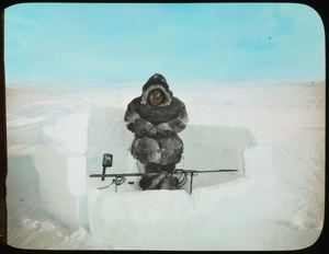 Image of Eskimo [Inuk] Sitting at Seal Hole